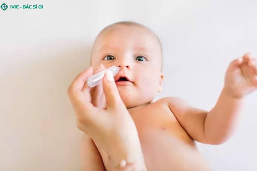 Nhỏ mũi bằng nước muối sinh lý giúp bé thông thoáng đường thở và dễ chịu hơn khi bị cúm A