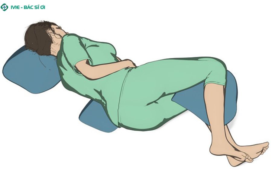 Tư thế nằm nghiêng và kê gối giữa hai chân phù hợp cho người bị thoát vị đĩa đệm vùng thắt lưng