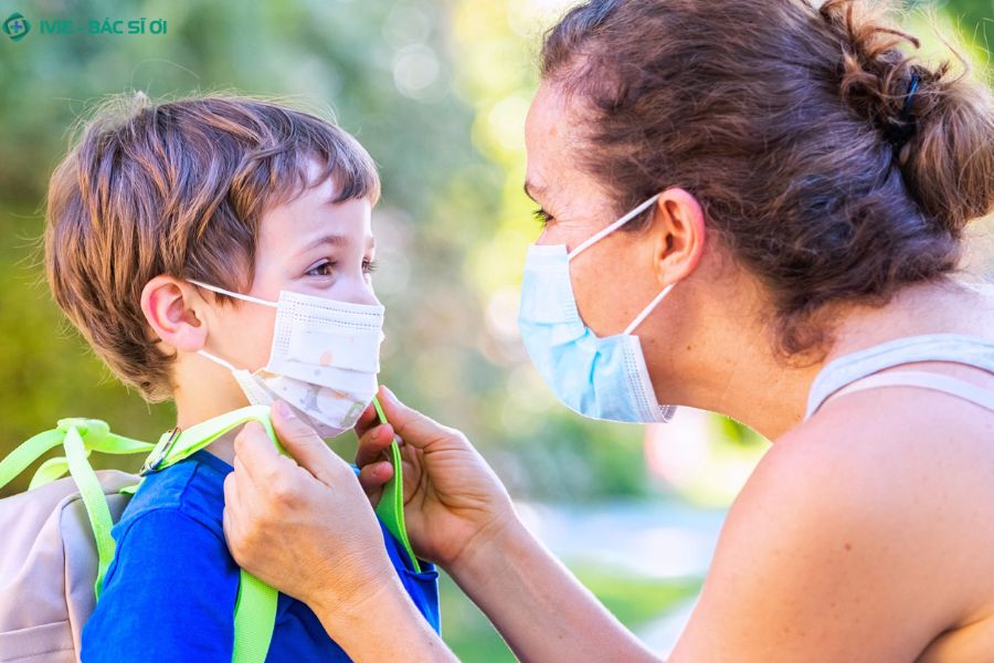 Cho bé đeo khẩu trang đúng cách để ngăn virus cúm A lây lan và bảo vệ sức khỏe cho cả gia đình