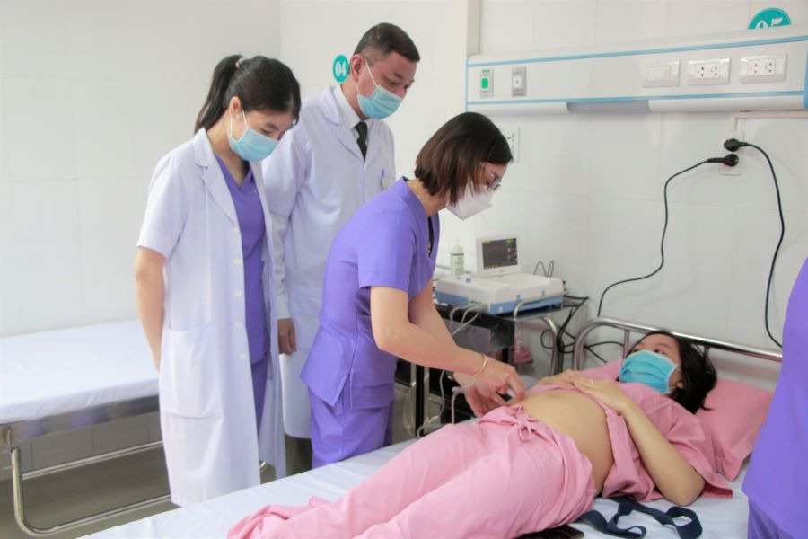 Bác sĩ dùng máy siêu âm để kiểm tra định kỳ cho thai phụ