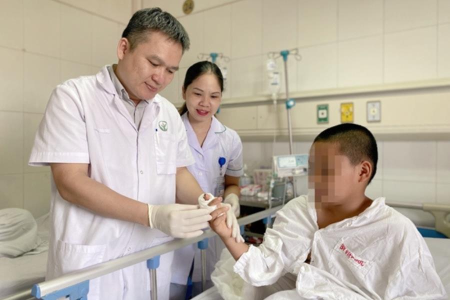 Bác sĩ Đào Văn Giang khám tay cho bé trai sau 4 ngày phẫu thuật